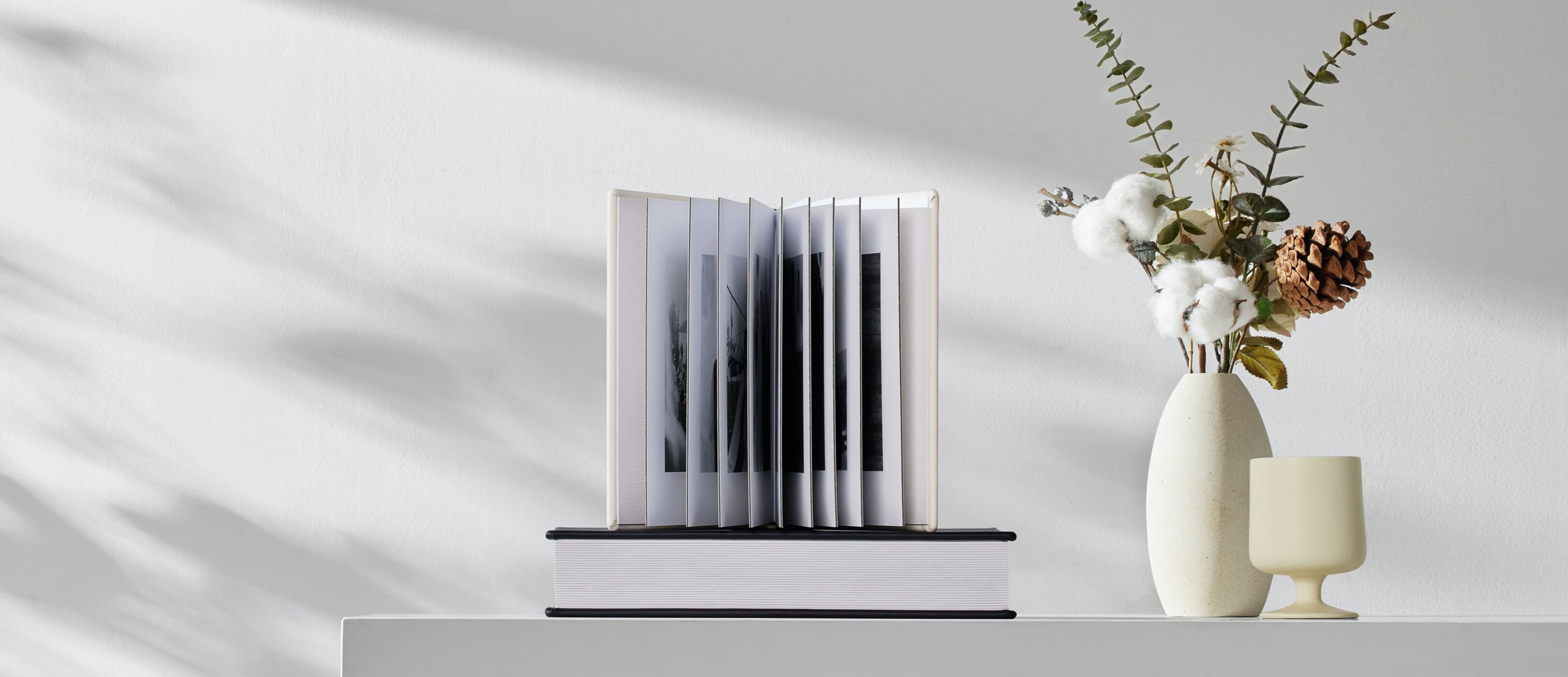 Open layflat photo book standing upright, showing archival pigment-printed spreads